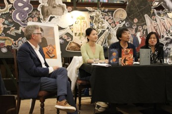 Four people on stage at a book release event