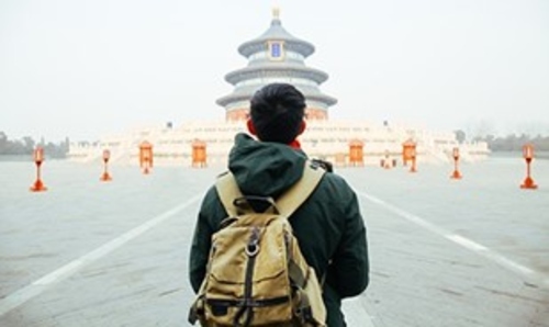 A student standing in front of a temple